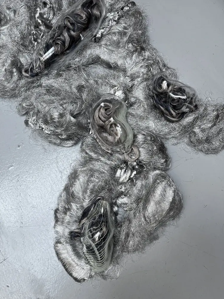 Scultura bozzolo in vetro soffiato su tappeto di fibre metalliche, bio-arte entomologico