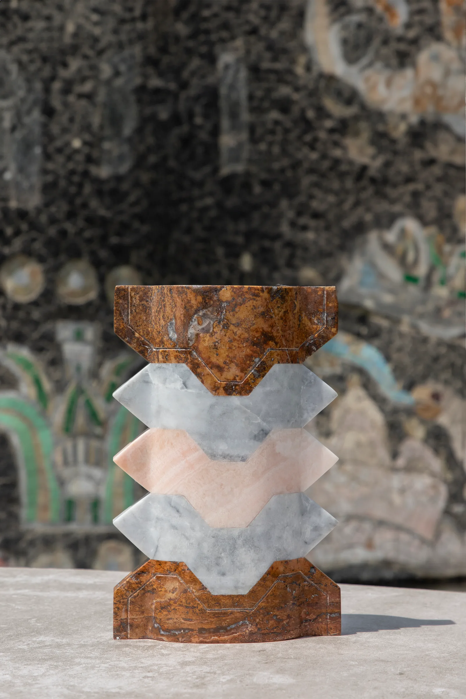 Místico III.II vase in red travertine, venetian marble, pink onyx — exhibition view