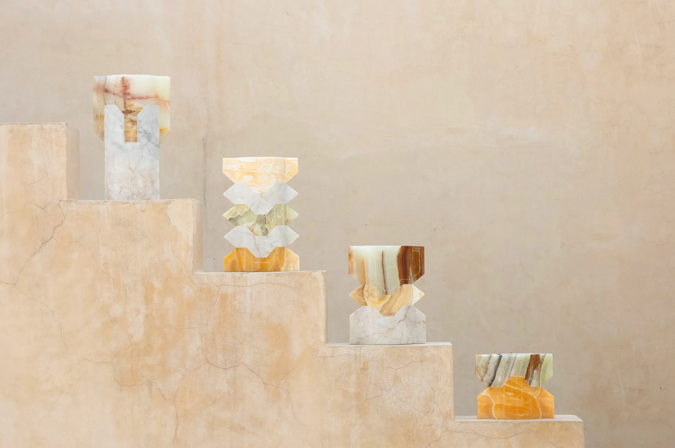 Four carved onyx and marble vases on a stepped stone plinth