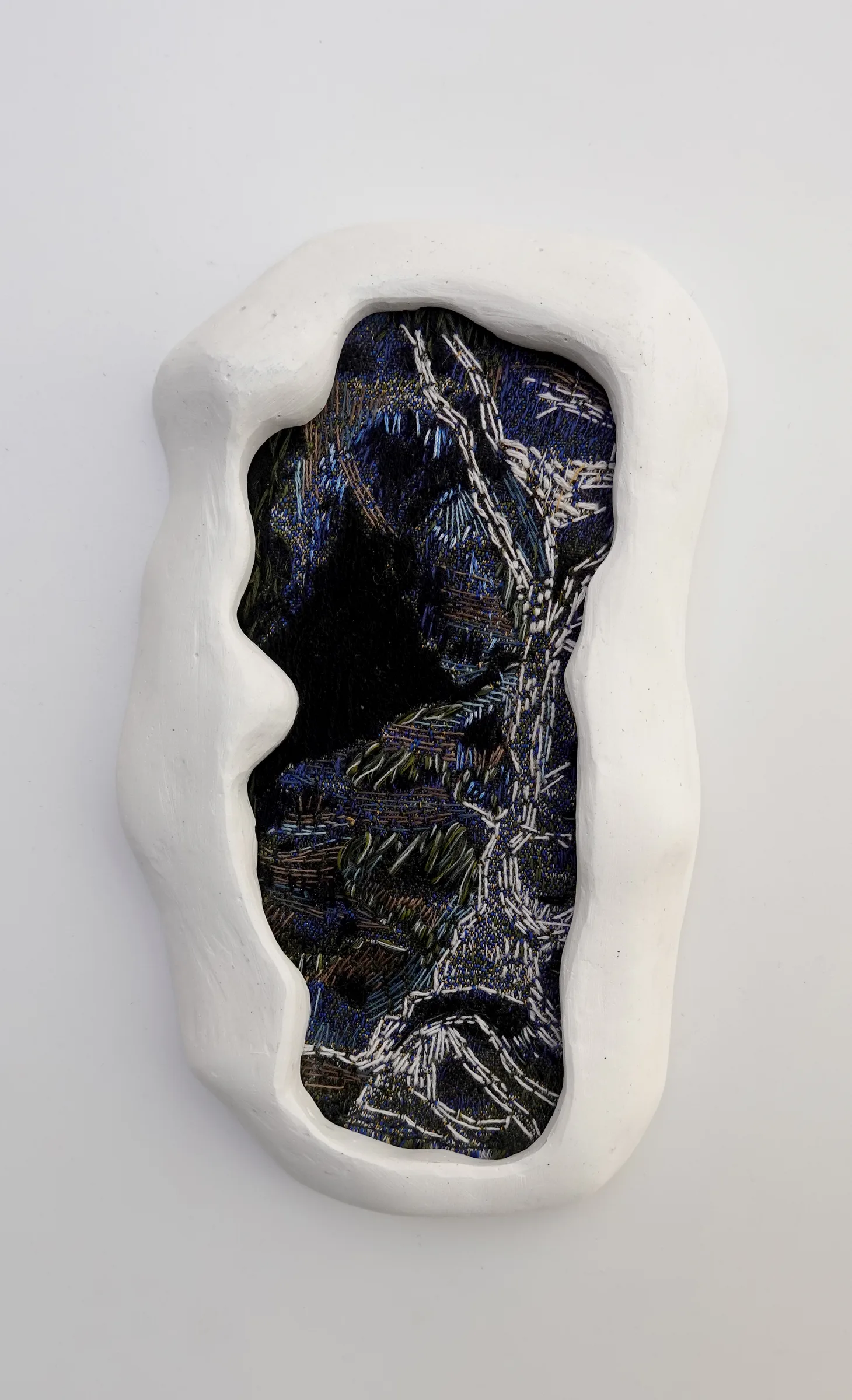 Memories 03, textil bordado en un marco de yeso blanco — vista de la obra