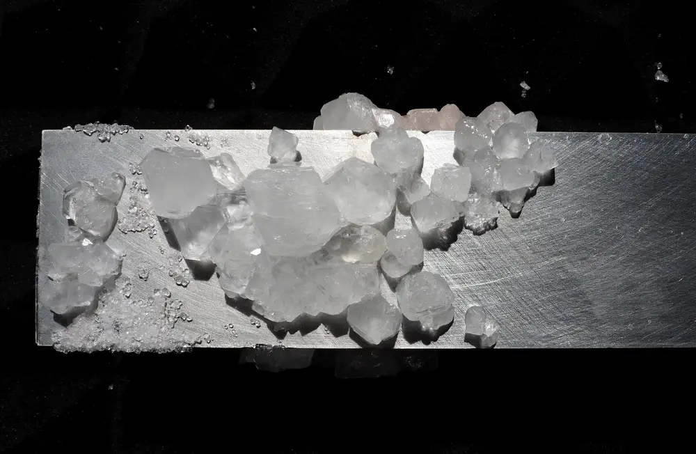 Crystals colonizing industrial waste — brushed metal bar, co-creation with matter, post-industrial aesthetics